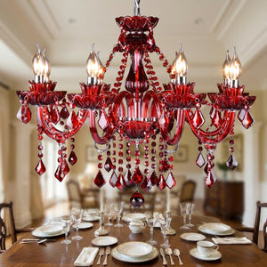 Lustre en cristal rouge éclairé au-dessus d'une table de salle à manger dressée