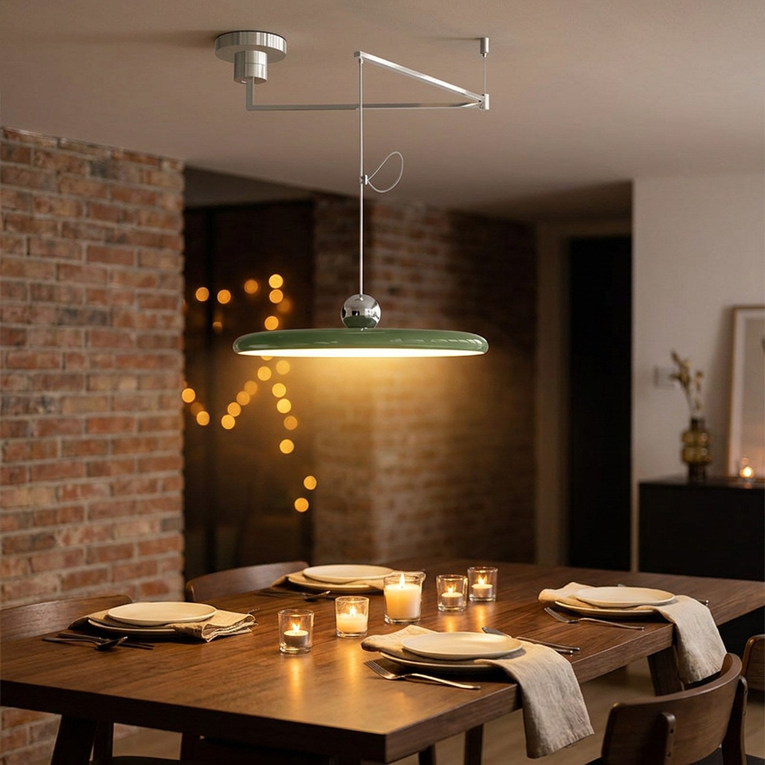 Lustre LED pivotant vert suspendu au-dessus d'une table à dîner en noyer avec couverts et bougies