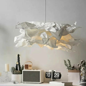 Lustre nuage papier blanc allumé au-dessus d'un bureau design avec radio vintage et horloge