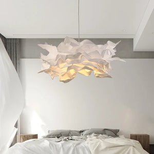 Lustre nuage papier blanc allumé au-dessus d'un lit dans une chambre moderne avec lampe de chevet
