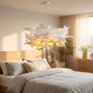 Lustre nuage papier DIY blanc allumé au-dessus d'un lit dans une chambre moderne et chaleureuse