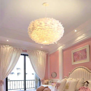 Lustre en plumes blanches suspendu dans une chambre enfant aux tons roses