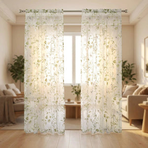 Voilage en tulle blanc à motif de fleurs vertes suspendu devant une baie vitrée lumineuse dans un salon