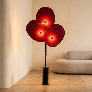 Lampadaire design 3 pétales en tissu rouge plissé style nordique dans un salon chaleureux