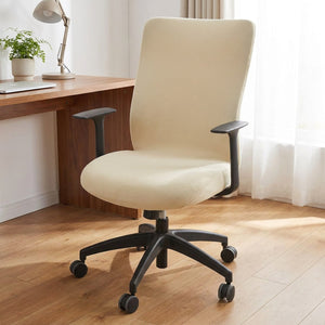 Housse de chaise de bureau beige installée sur un fauteuil pivotant devant un bureau en bois