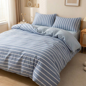 Housse de couette rayee bleue et blanche posee sur un lit fait dans une chambre lumineuse