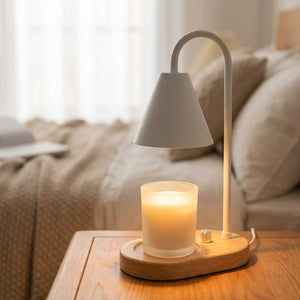 Chauffe-bougie électrique blanc allumé au-dessus d'un pot de cire sur une table de chevet en bois