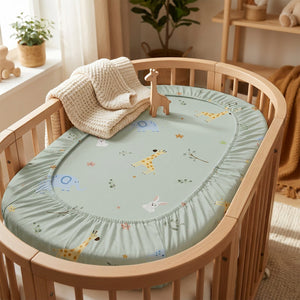 Drap housse berceau bébé vert sauge motif girafe et éléphant sur un lit en bois