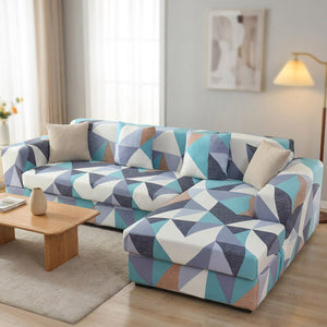 Housse de canapé extensible motif géométrique bleu installée sur un canapé d'angle moderne dans un salon lumineux