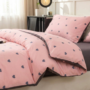 Housse de couette rose à petits cœurs avec taies assorties sur un lit fait