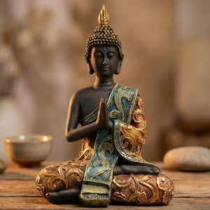 Statue de bouddha thaï artisanale en résine noire posée sur une étagère en bois dans une ambiance zen