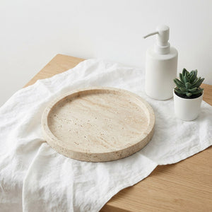 Plateau rond en pierre naturelle travertin sur linge blanc