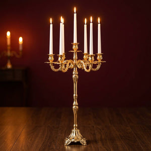 Chandelier candélabre à 7 bras en métal doré avec bougies allumées dans un salon élégant