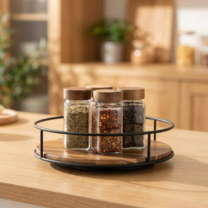 Plateau tournant en bois d'acacia avec rebord en métal noir garni de pots à épices sur un plan de travail de cuisine