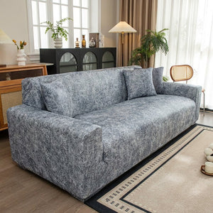 Housse de canapé jacquard gris installée dans un salon lumineux