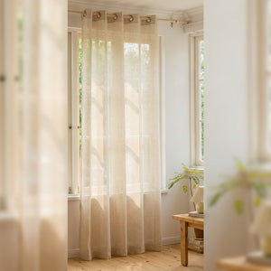 Voilage beige en voile aspect lin suspendu à une tringle devant une fenêtre lumineuse dans un salon