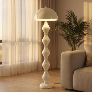 Lampadaire champignon nordique au dôme arrondi et pied ondulé posé dans un salon chaleureux