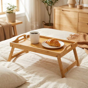 Plateau de lit en bambou pliable avec tasse de café et croissant sur un lit cosy