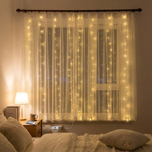 Rideau lumineux LED blanc chaud suspendu à une fenêtre dans une chambre douillette de nuit