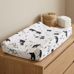 Housse de matelas à langer motif ours noir posée sur une commode dans une chambre de bébé
