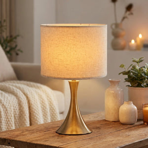 Abat-jour tambour en lin beige sur lampe de table avec lumière chaleureuse allumée