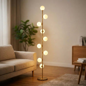 Lampadaire doré à neuf globes de verre dépoli allumés dans un salon moderne chaleureux