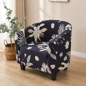Housse de fauteuil cabriolet extensible imprimée motif floral bleu marine sur un fauteuil club dans un salon lumineux