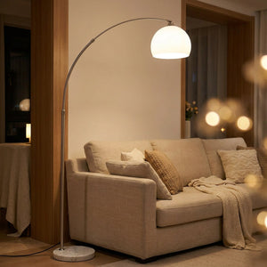 Lampadaire arc avec dôme en verre blanc et socle en marbre dans un salon moderne