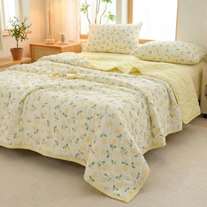 Couette matelassée à imprimé fleuri posée sur un lit dans une chambre lumineuse