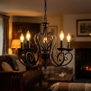 Lustre industriel en fer forgé noir à bougies suspendu dans un salon chaleureux