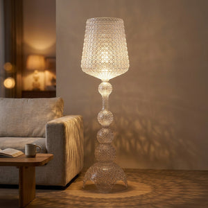 Lampadaire design acrylique transparent ajouré façon dentelle allumé dans un salon chaleureux