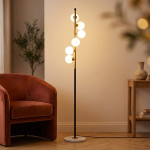 Lampadaire nordique à cinq boules de verre en spirale sur tige dorée avec base en marbre blanc dans un salon élégant