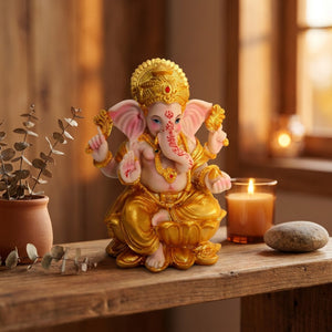 Statue de Ganesha en résine dorée sur étagère bois avec bougie et eucalyptus dans un intérieur chaleureux