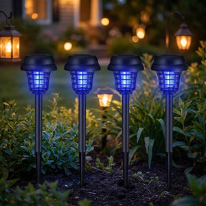 Quatre lampes solaires anti-moustiques UV allumées plantées dans un jardin au crépuscule
