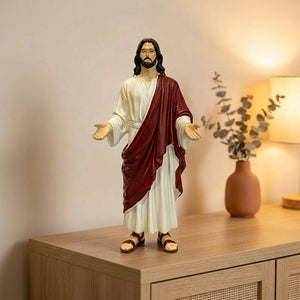 Statue de Jésus-Christ au Sacré-Cœur en résine bras ouverts posée sur une console décorée