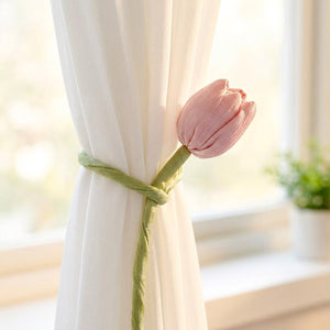 Embrasse de rideau tulipe rose en tissu retenant un voilage blanc devant une fenetre lumineuse