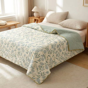 Couette d'été fleurie verte en gaze de coton lavé sur un lit dans une chambre lumineuse