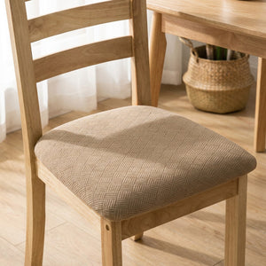 Housse de siège de chaise en jacquard beige installée sur une chaise en bois dans une salle à manger