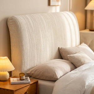 Housse de tête de lit beige en velours jacquard installée sur une tête de lit dans une chambre lumineuse