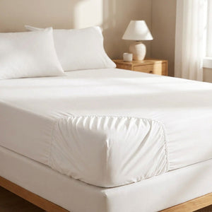 Drap-housse en coton égyptien blanc installé sur un lit dans une chambre lumineuse