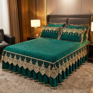 Couvre-lit en velours vert foncé à broderie dorée et jupe en dentelle sur un lit dans une chambre chaleureuse