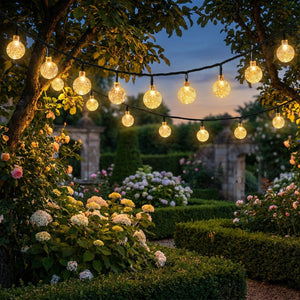 Guirlande solaire LED boules de cristal dans un jardin au crépuscule