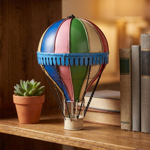 Ballon à air chaud décoratif en métal forgé coloré posé sur une étagère en bois dans un salon chaleureux
