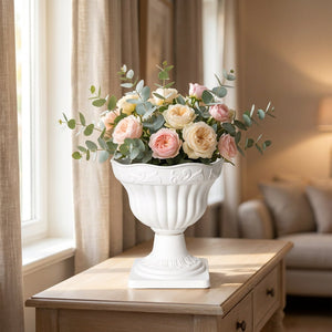 Cache-pot sur pied colonne romaine blanc garni de fleurs sur une console en bois