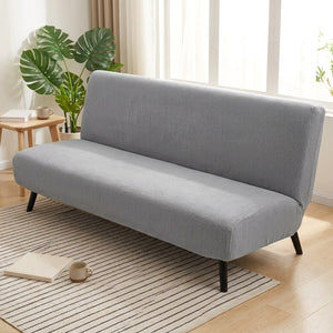 Housse de canapé lit futon grise dans un salon lumineux avec plante verte