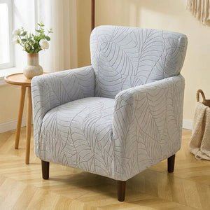 Housse de fauteuil club gris clair au motif jacquard feuilles dans un salon lumineux