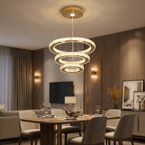 Lustre en cristal doré à trois anneaux suspendu au-dessus d'une table de salle à manger élégante