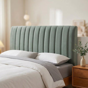 Housse de tête de lit en peluche matelassée grise installée sur un lit dans une chambre chaleureuse