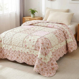 Couvre-lit matelassé en coton à motif floral rose posé sur un lit dans une chambre lumineuse