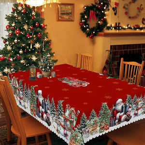 Nappe de Noël rectangulaire rouge dépliée sur une grande table montrant le motif village enneigé